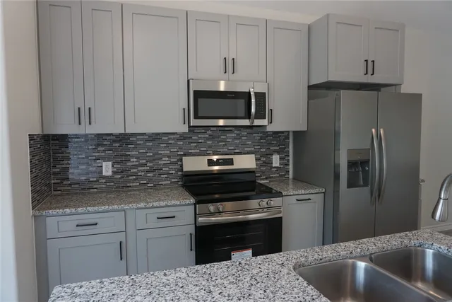 a kitchen with stainless steel appliances granite countertop a sink stove and refrigerator