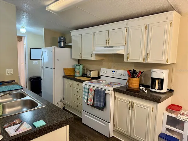 a kitchen with white cabinets and white appliances