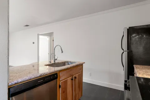 a close view of a sink and dishwasher with wooden floor