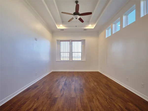 an empty room with a window and a fan