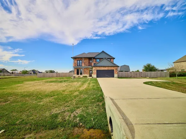 a front view of a house with a garden and lake view