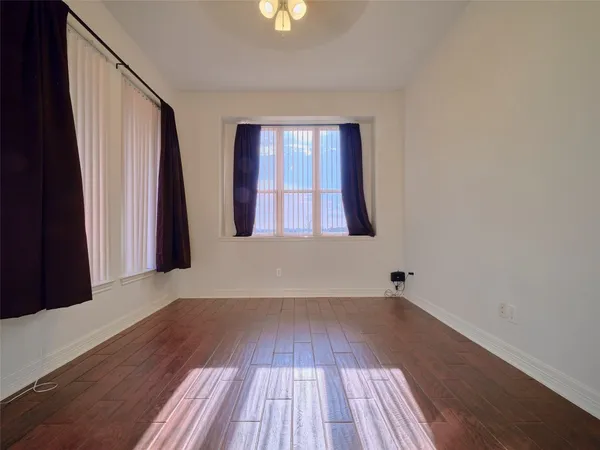 a view of a room with a chandelier and wooden floor