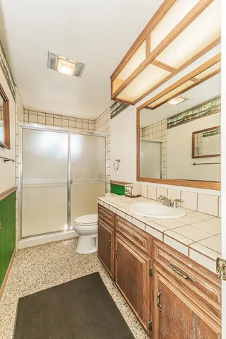 a bathroom with a granite countertop sink and a mirror