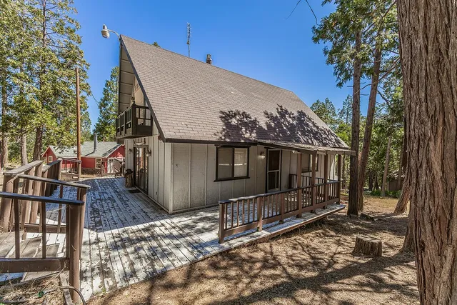a view of a house with a yard and wooden fence