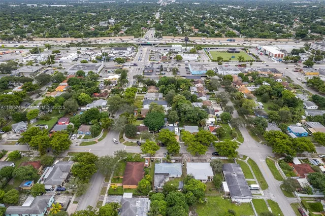 an aerial view of residential houses with outdoor space and trees