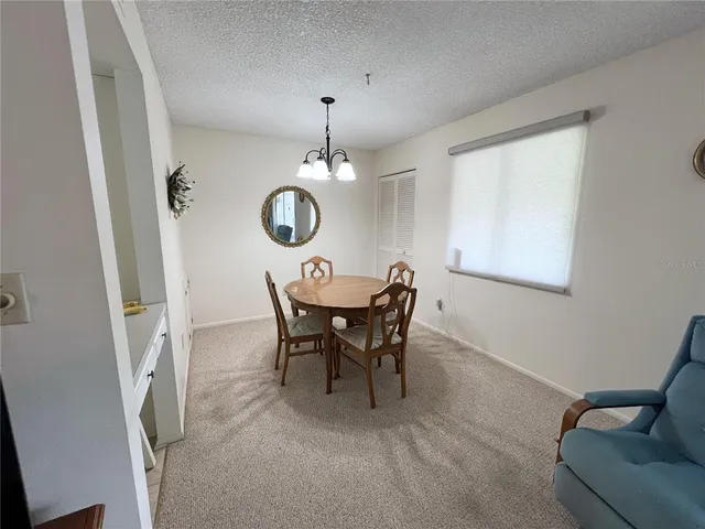 a view of a dining room with furniture and chandelier