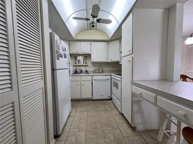 a kitchen with cabinets a sink and white stainless steel appliances