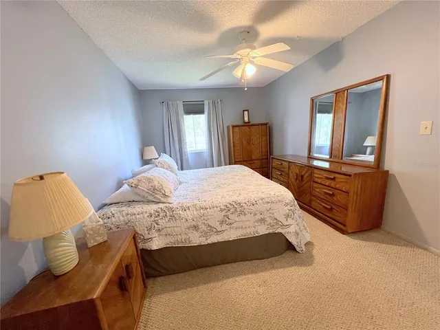 a bedroom with a bed and a lamp on dresser