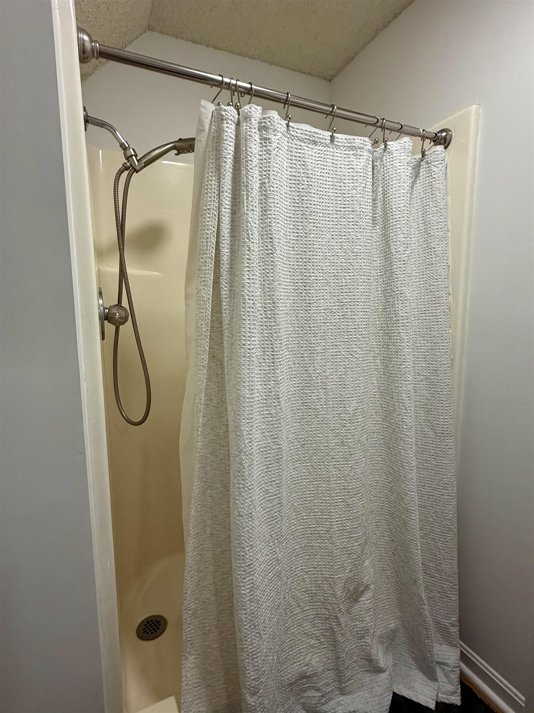 142 Treece Street Selmer, TN 38375 - Photo 20 of 36 Shower stall with a brushed nickel showerhead and handheld sprayer, featuring a coordinating shower rod