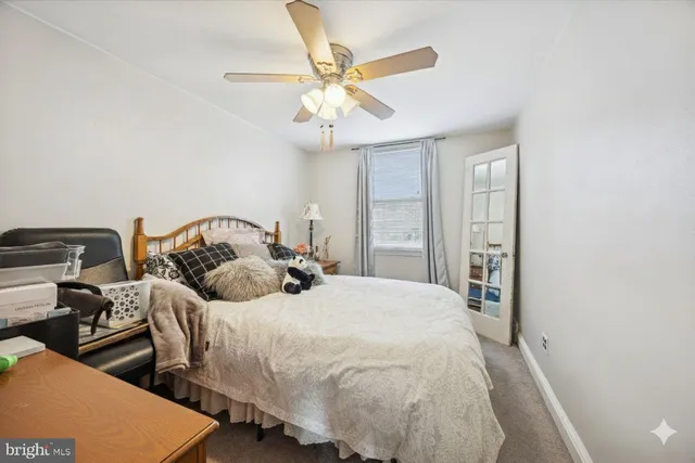 a bedroom with two beds and ceiling fan