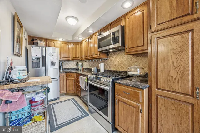 a kitchen with stainless steel appliances granite countertop a stove top oven a sink dishwasher and cabinets with wooden floor
