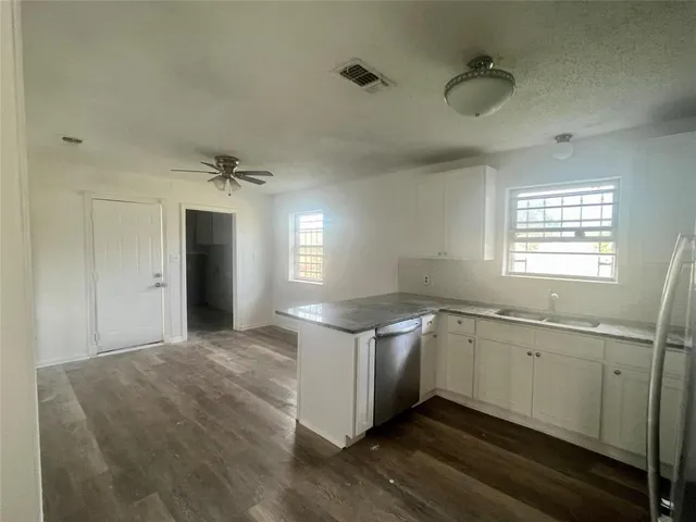 a kitchen with stainless steel appliances granite countertop a sink and dishwasher with wooden floor