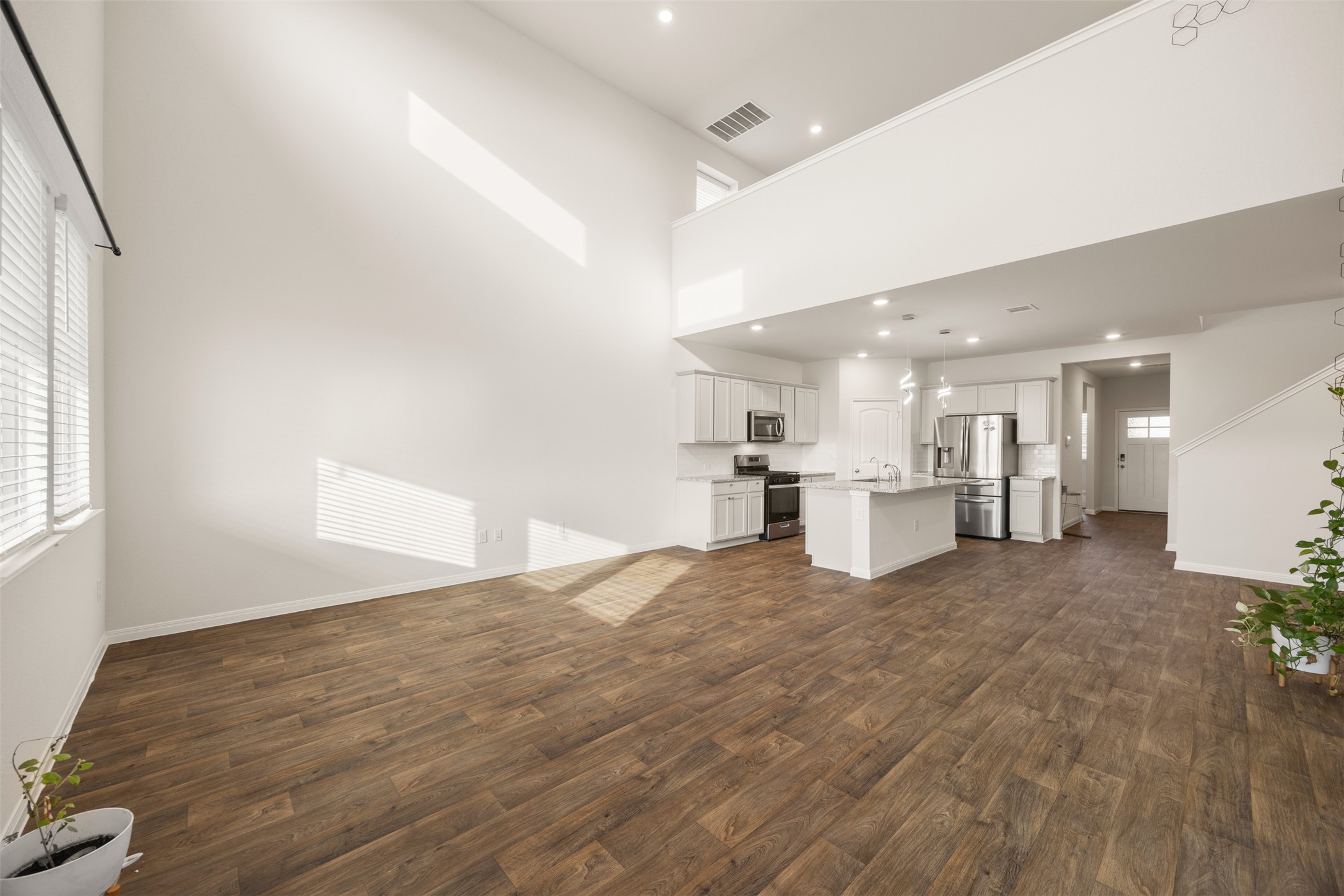 413 Emerald Cove Georgetown, TX 78626 - Photo 14 of 15 Kitchen with an island with sink, open floor plan, dark wood finished floors, white cabinets, and appliances with stainless steel finishes