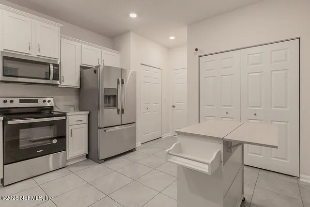 a kitchen with stainless steel appliances a refrigerator stove and microwave