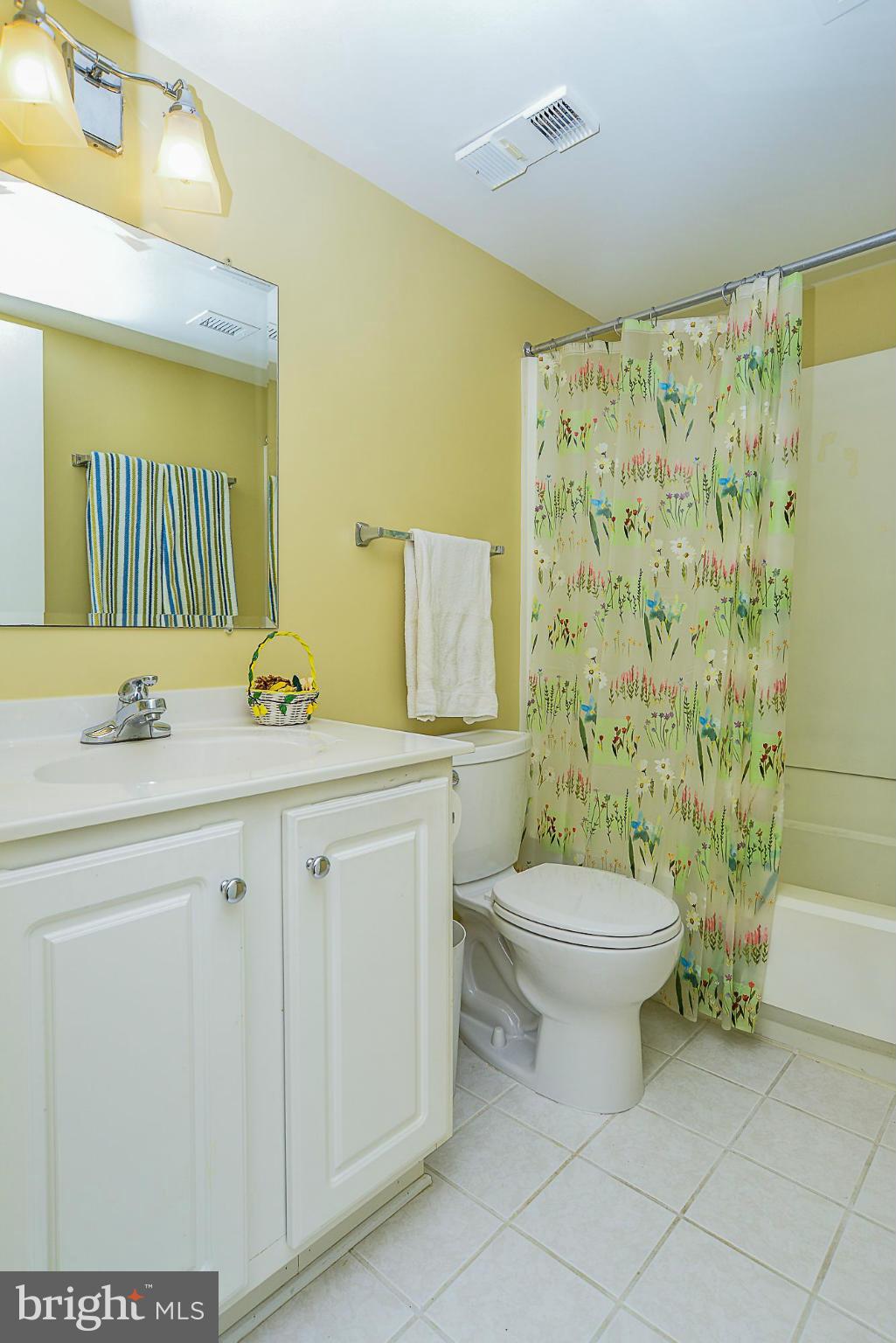 5932 Cove Landing Road, Unit 201D Burke, VA 22015 - Photo 14 of 24 a bathroom with a granite countertop toilet sink and a mirror