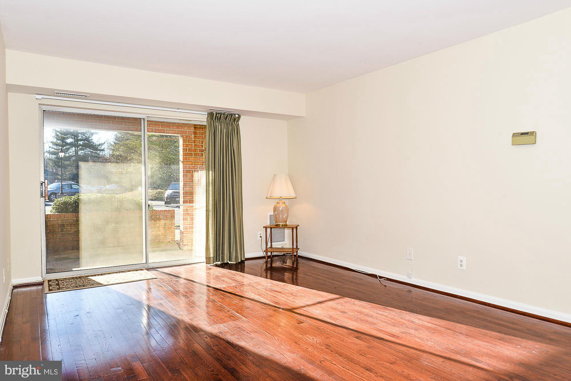 5932 Cove Landing Road, Unit 201D Burke, VA 22015 - Photo 3 of 24 an empty room with wooden floor and a window