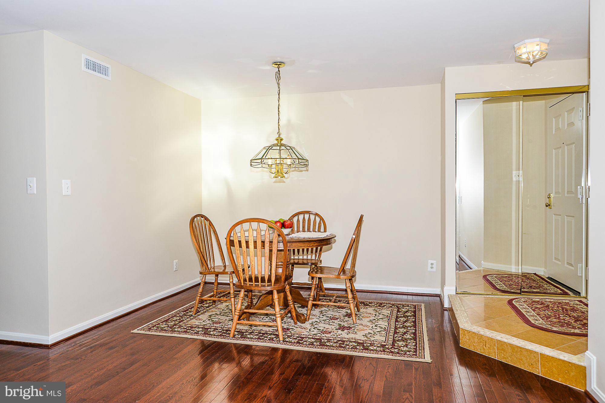 5932 Cove Landing Road, Unit 201D Burke, VA 22015 - Photo 6 of 24 a dining room with furniture and wooden floor