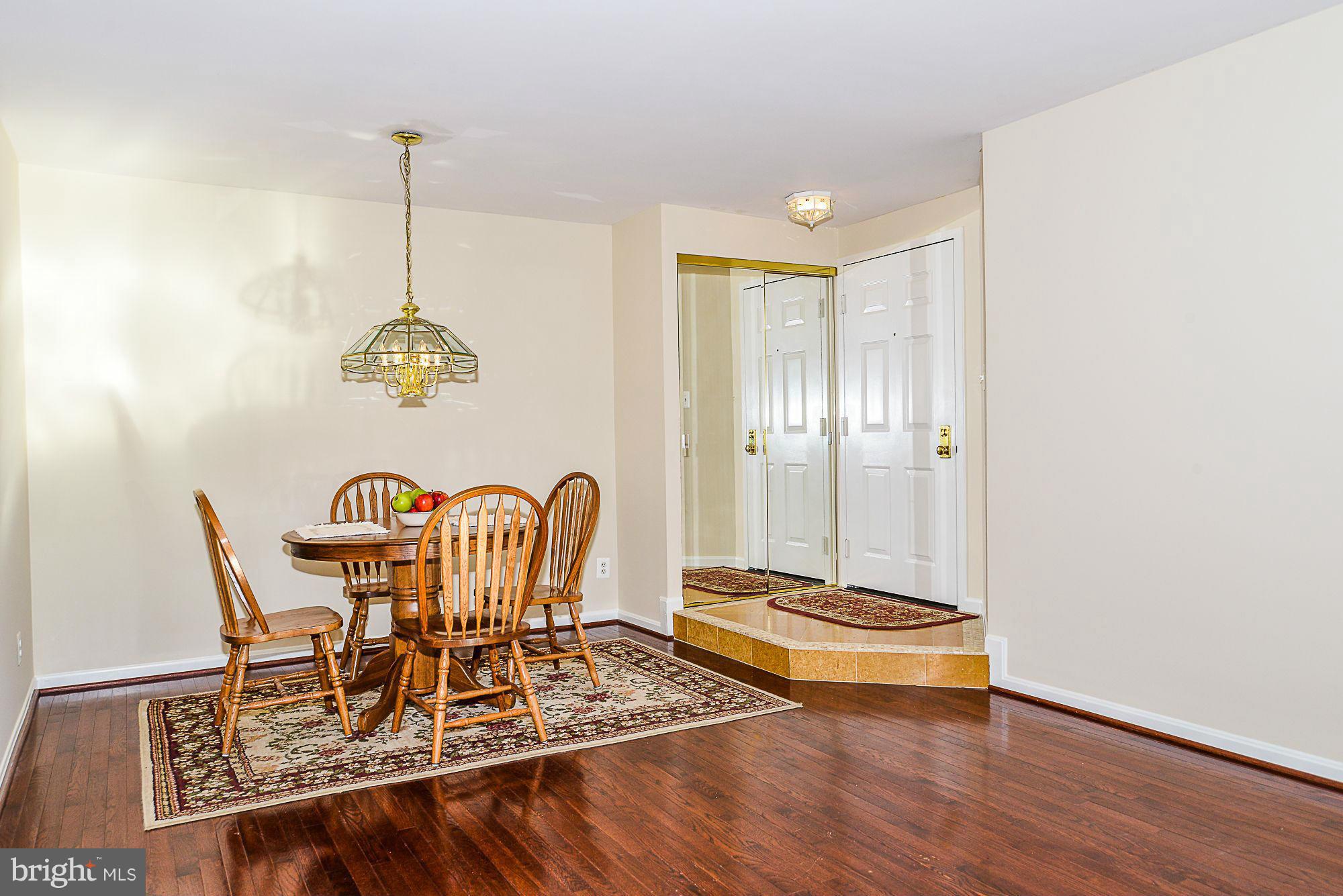 5932 Cove Landing Road, Unit 201D Burke, VA 22015 - Photo 7 of 24 a view of a dining room with furniture wooden floor and chandelier