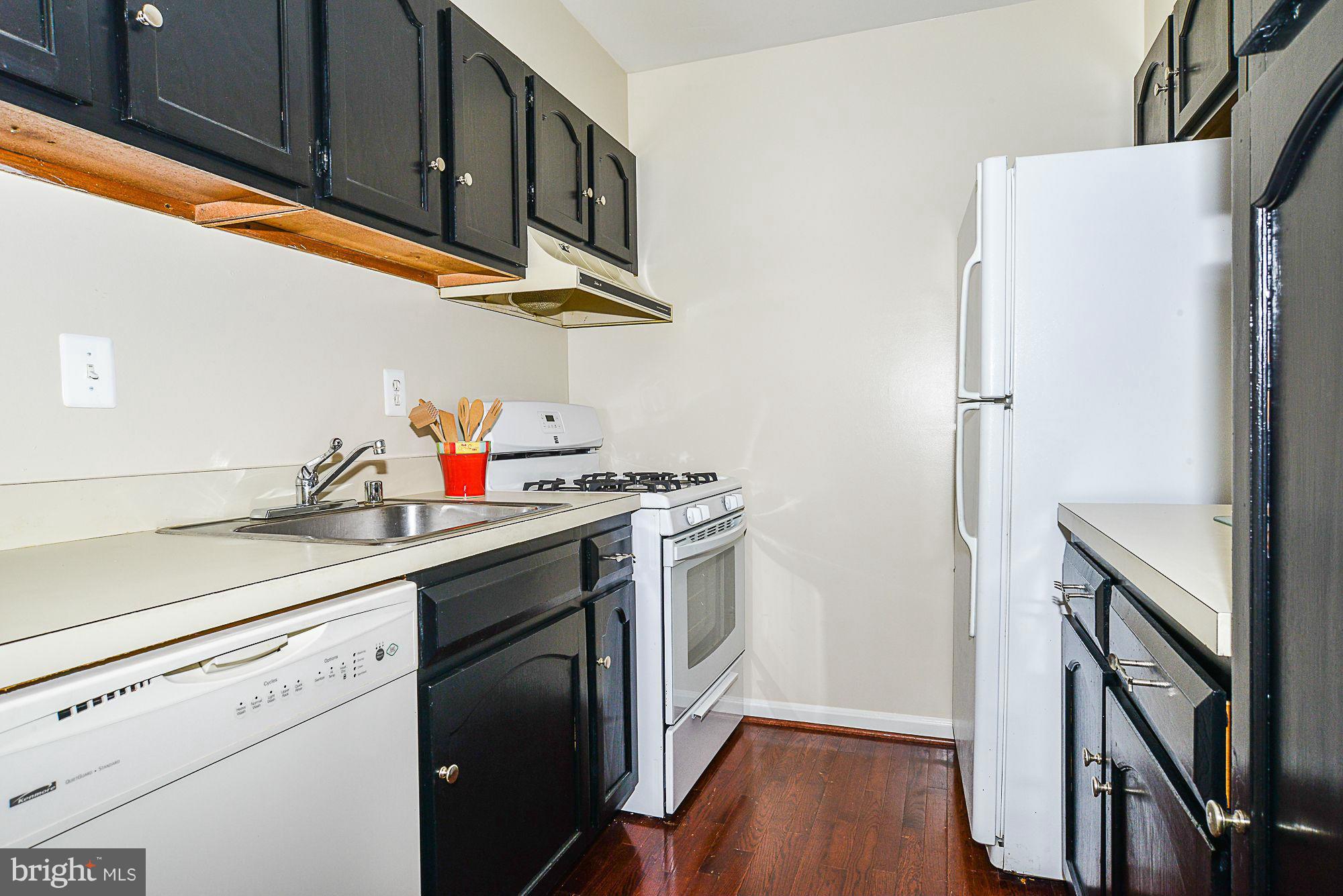 5932 Cove Landing Road, Unit 201D Burke, VA 22015 - Photo 10 of 24 a kitchen with stainless steel appliances a sink a stove and a refrigerator