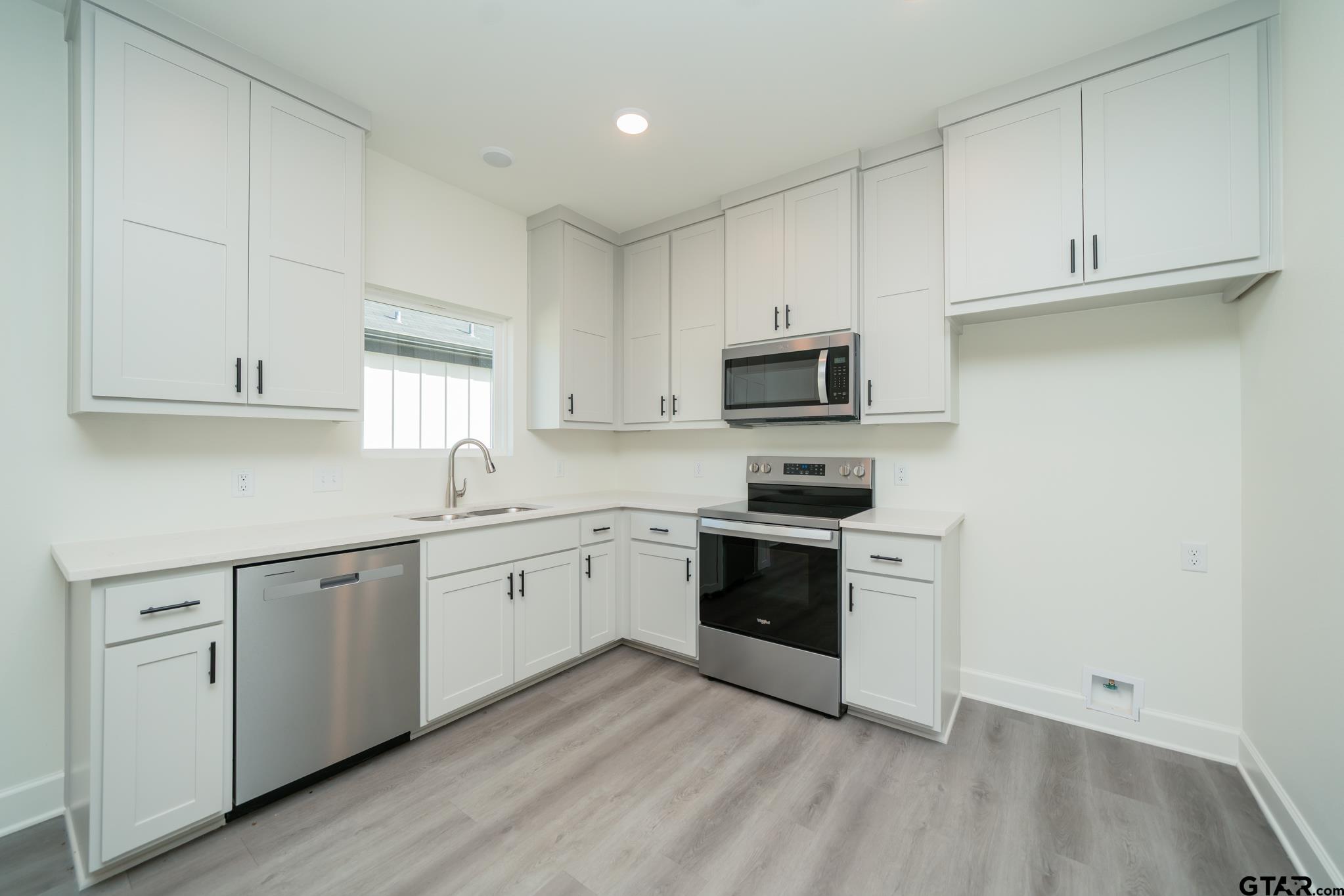 390 Alexander Street Kilgore, TX 75662 - Photo 11 of 34 a kitchen with granite countertop white cabinets and stainless steel appliances
