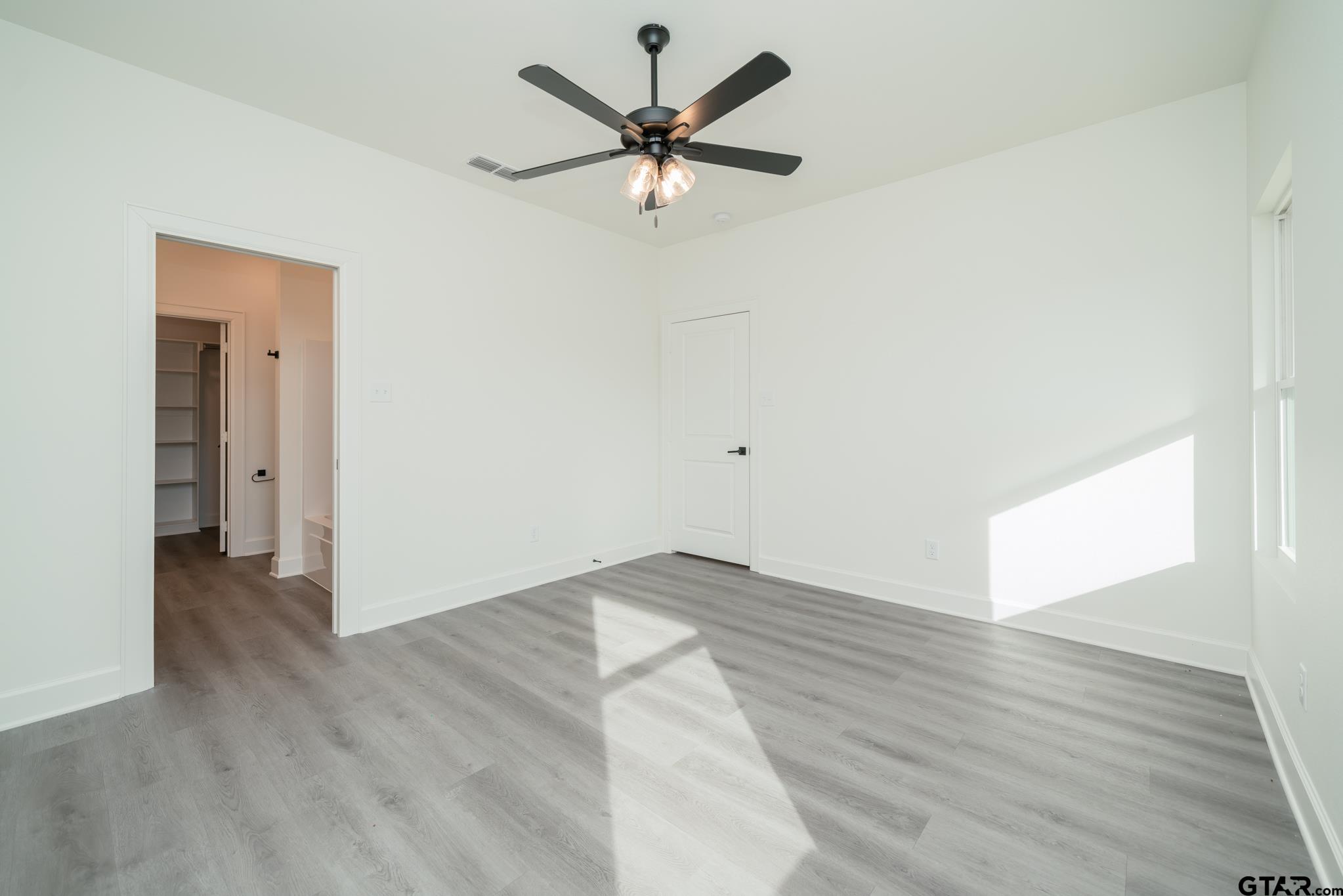 390 Alexander Street Kilgore, TX 75662 - Photo 15 of 34 an empty room with wooden floor and a ceiling fan