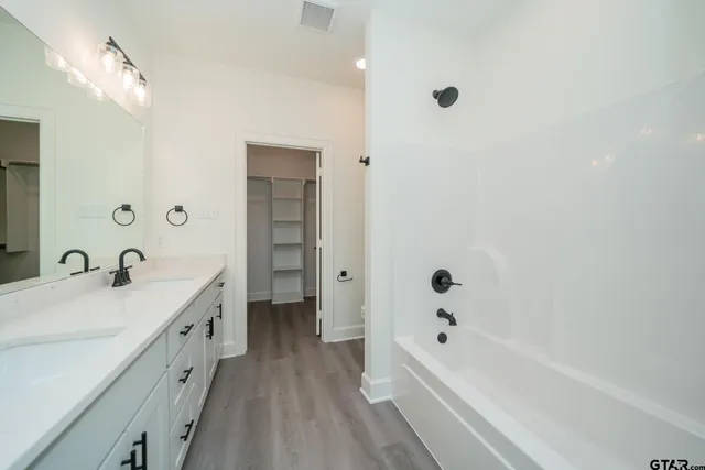 a bathroom with a tub a sink and mirror