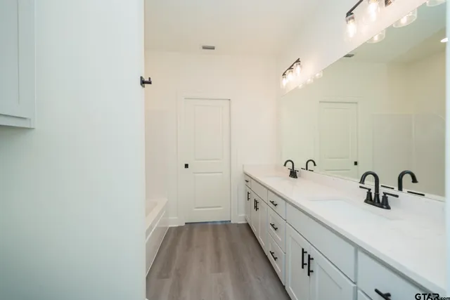 an empty room with wooden floor and ceiling fan