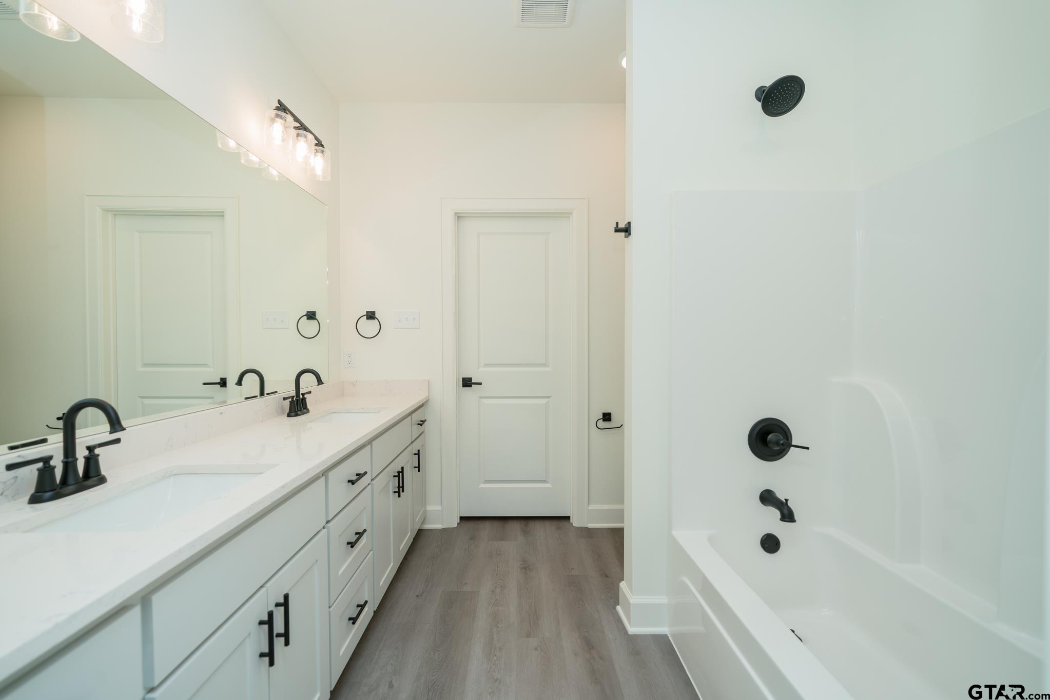 390 Alexander Street Kilgore, TX 75662 - Photo 23 of 34 a bathroom with a tub a sink and mirror