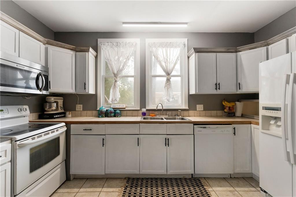 712 College Street Calhoun, GA 30701 - Photo 8 of 31 a kitchen with stainless steel appliances granite countertop a stove a sink and a refrigerator