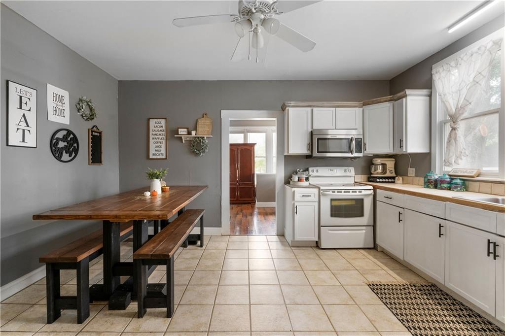 712 College Street Calhoun, GA 30701 - Photo 10 of 31 a kitchen with stainless steel appliances a table chairs and a refrigerator