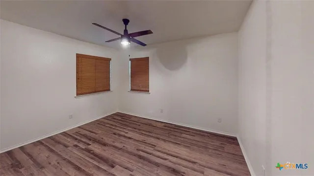 a view of empty room with wooden floor