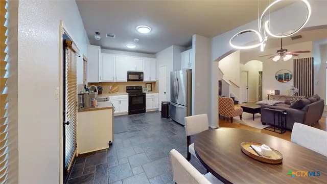 a living room with furniture kitchen and a chandelier