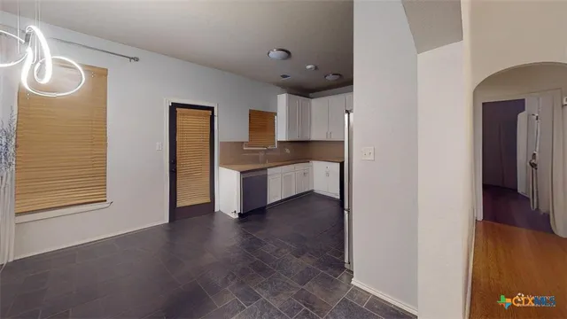 a view of a kitchen with wooden floor and electronic appliances