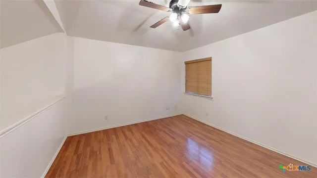 an empty room with a window and a fan