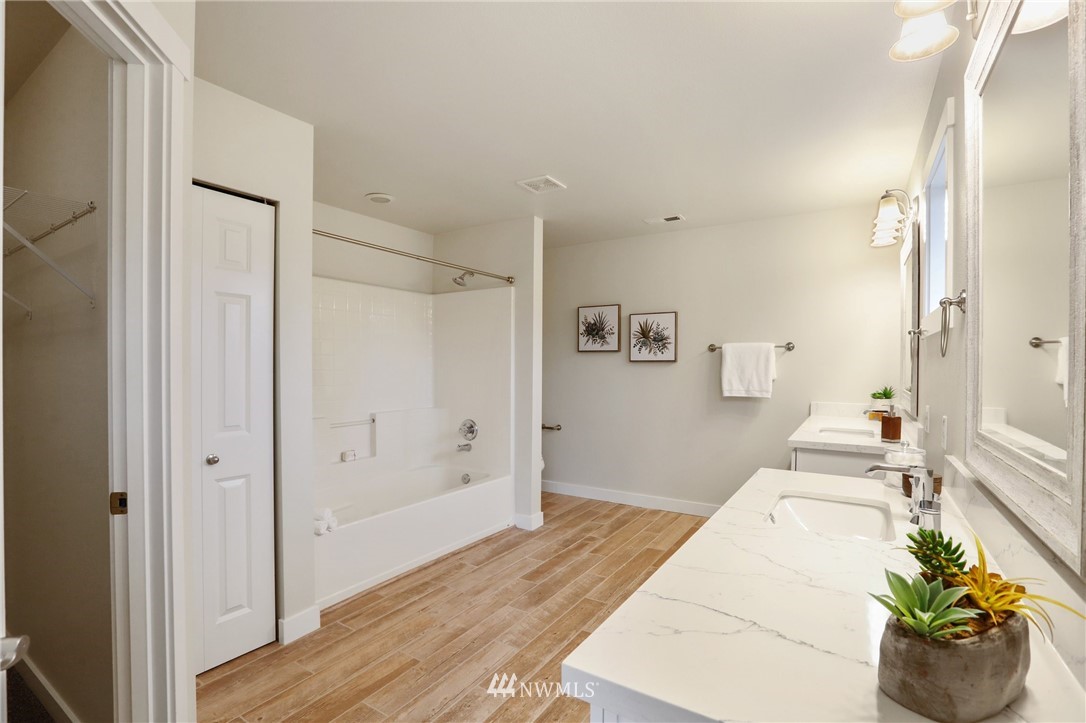 20329 Corbridge Road Southeast Monroe, WA 98272 - Photo 22 of 38 a hallway with wooden floor and a bathroom