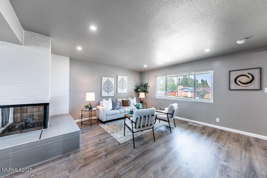 3390 Cashill Boulevard Reno, NV 89509 - Photo 11 of 51 a living room with fireplace furniture wooden floor and a window