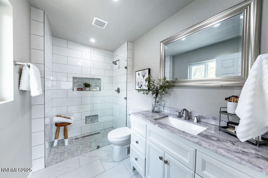 3390 Cashill Boulevard Reno, NV 89509 - Photo 31 of 51 a bathroom with a granite countertop sink a toilet and shower