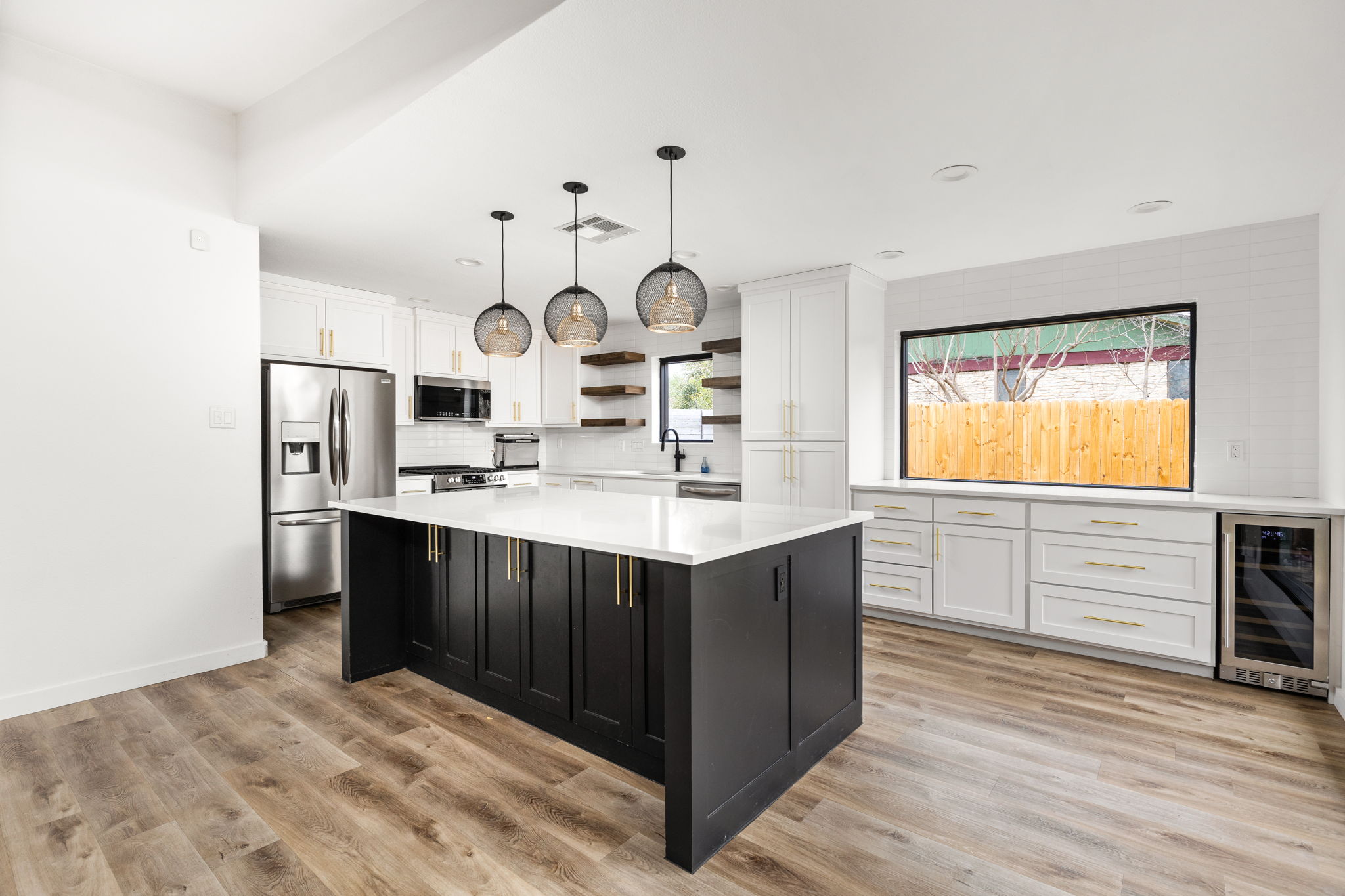 612 Meadowbrook Drive Georgetown, TX 78628 - Photo 12 of 35 Kitchen with two tone cabinetry, open shelves, stainless steel appliances, pendant lighting, and beverage cooler