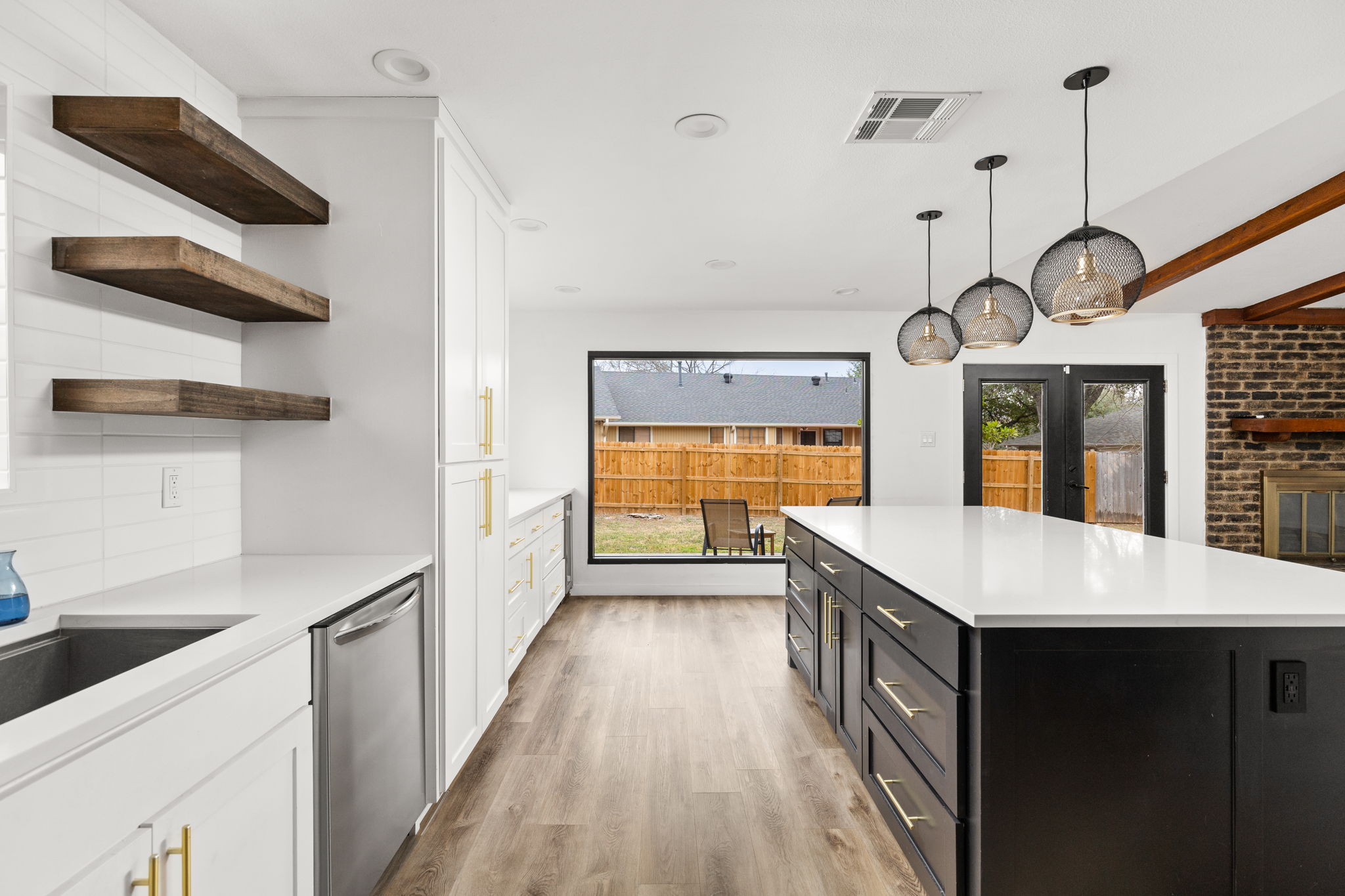612 Meadowbrook Drive Georgetown, TX 78628 - Photo 14 of 35 Dual tone kitchen featuring dual tone cabinets, dishwasher, hanging light fixtures, light wood-type flooring, and beam ceiling