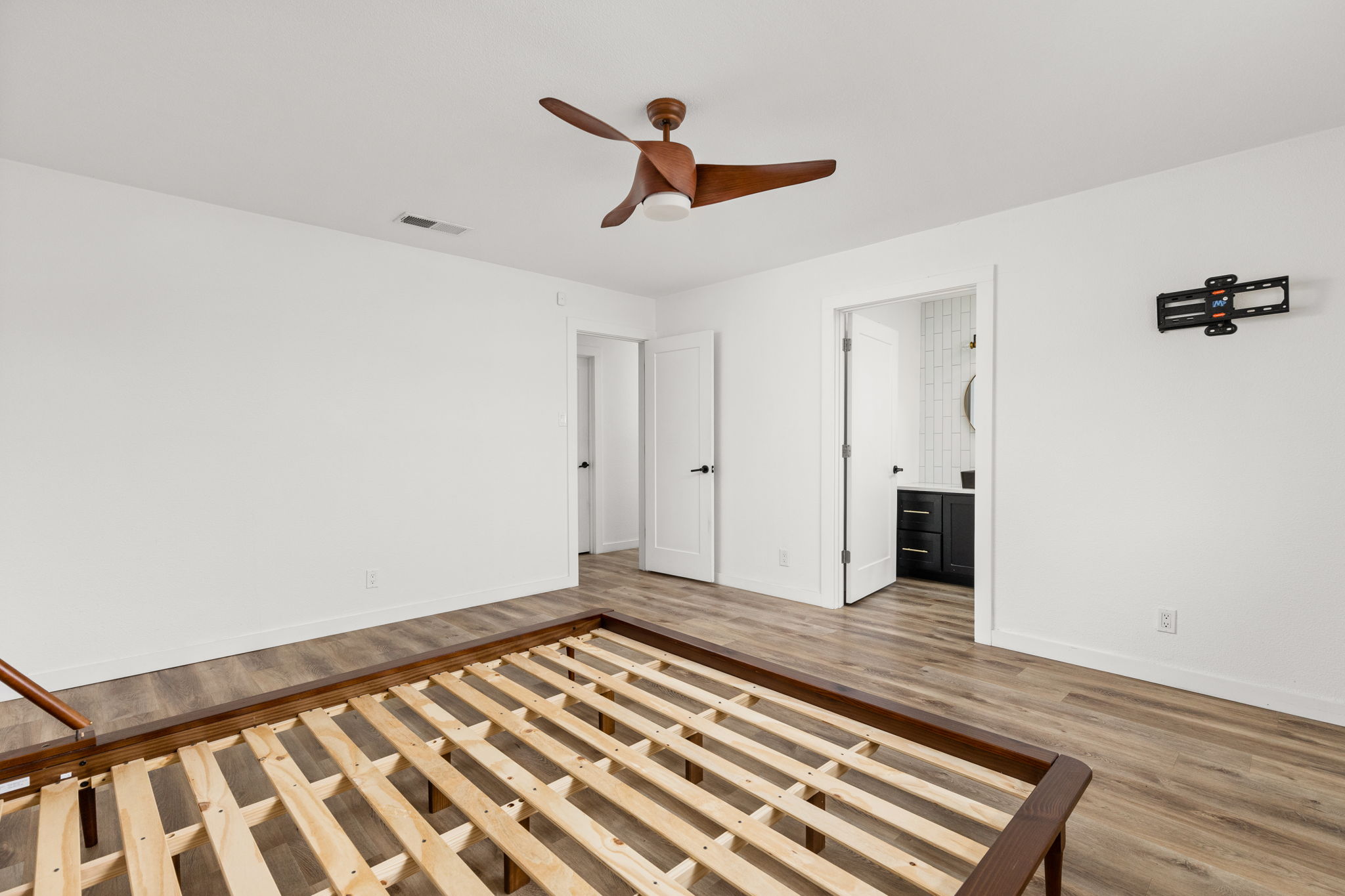 612 Meadowbrook Drive Georgetown, TX 78628 - Photo 19 of 35 Unfurnished bedroom with wood finished floors, a ceiling fan, and connected bathroom