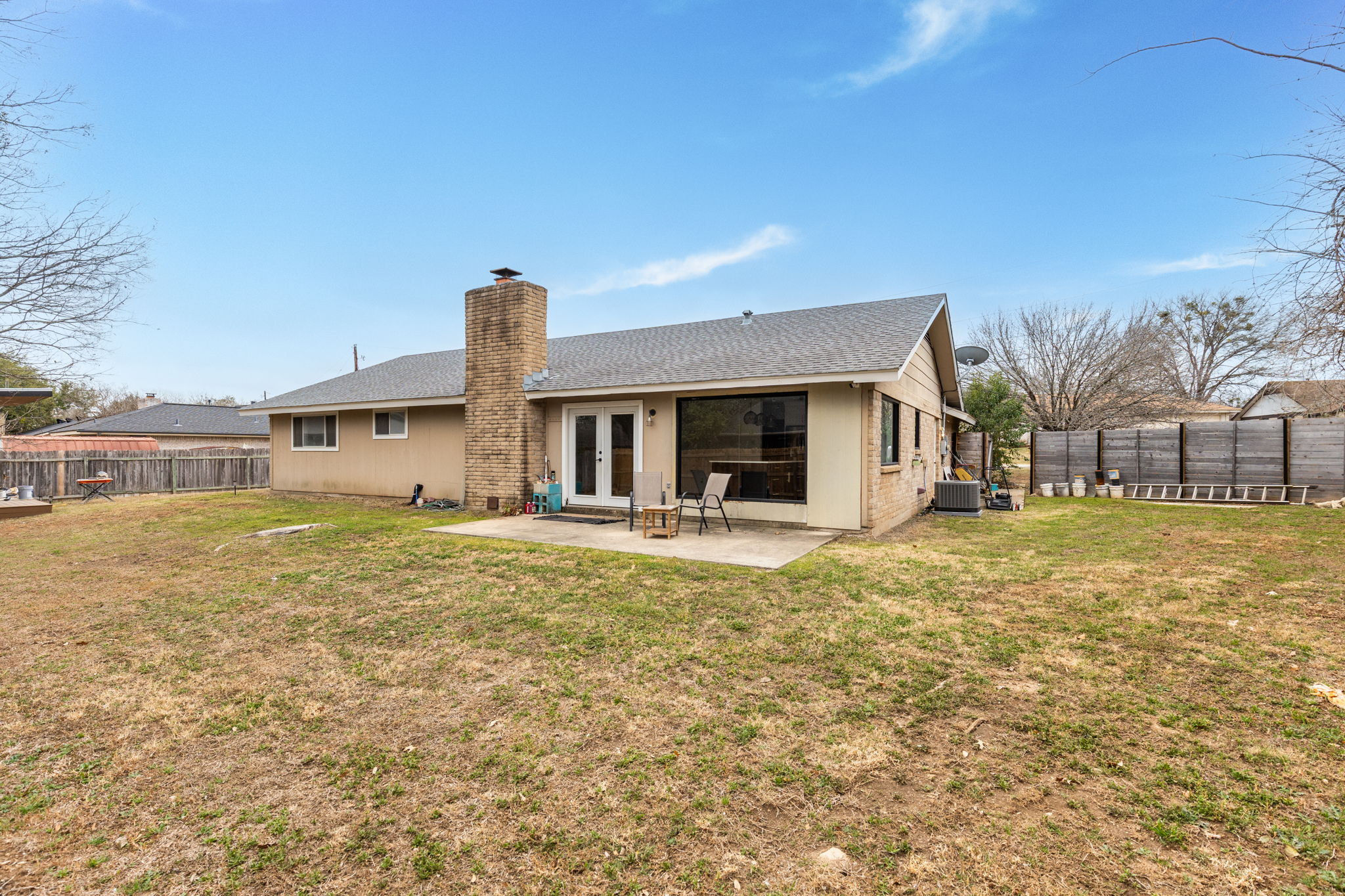 612 Meadowbrook Drive Georgetown, TX 78628 - Photo 30 of 35 Back of house featuring french doors, a fenced backyard, a chimney, a patio, and roof with shingles