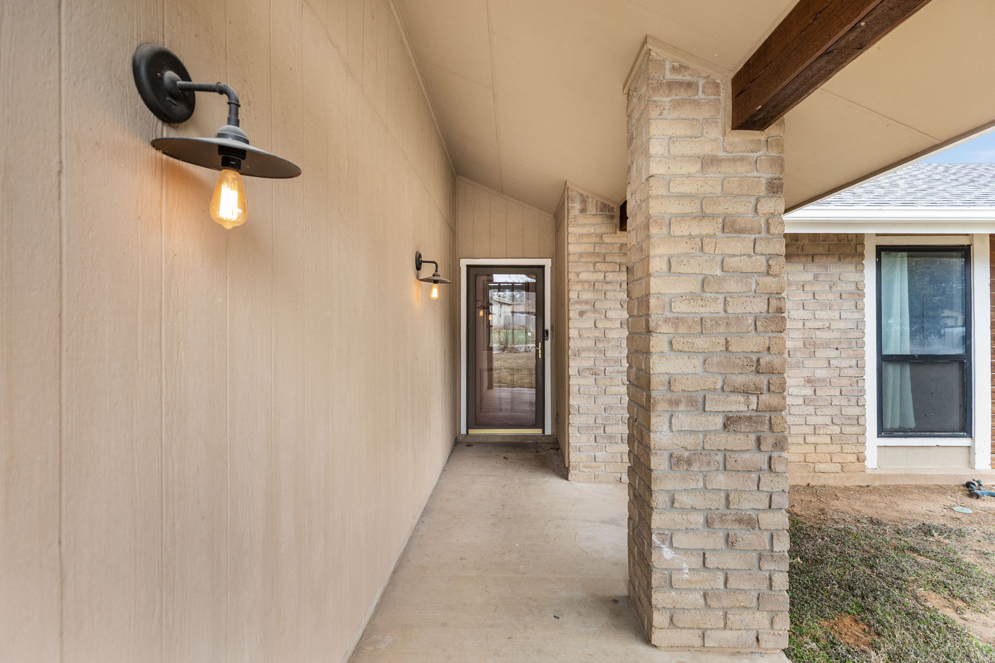 612 Meadowbrook Drive Georgetown, TX 78628 - Photo 5 of 35 Doorway to property featuring brick siding and roof with shingles
