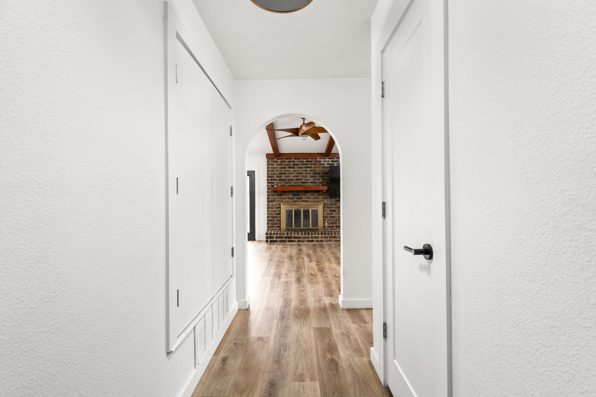 612 Meadowbrook Drive Georgetown, TX 78628 - Photo 7 of 35 Corridor with a textured wall, arched walkways, and light wood-style floors