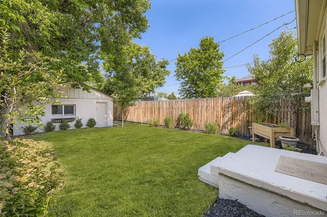 a backyard of a house with table and chairs