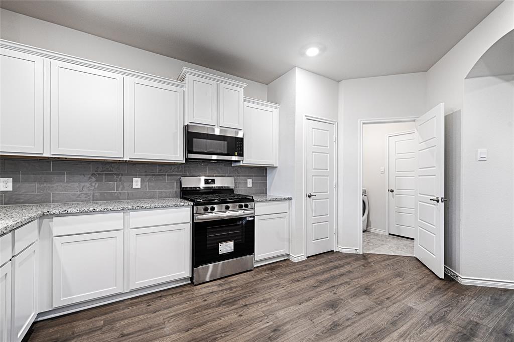 2427 Grapevine Way Celina, TX 75009 - Photo 11 of 38 a kitchen with stainless steel appliances granite countertop a stove a sink and a microwave