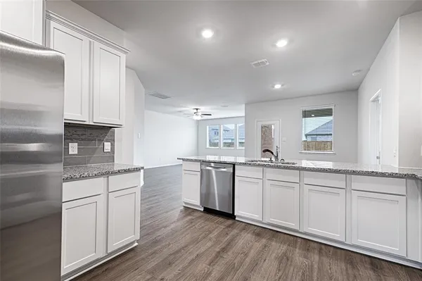 a kitchen with granite countertop white cabinets and white appliances