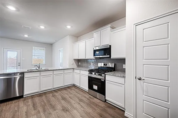 a kitchen with granite countertop white cabinets and white appliances