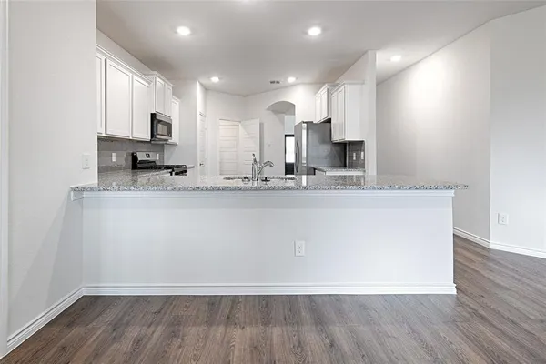 a large kitchen with stainless steel appliances granite countertop a large stove a sink and a microwave