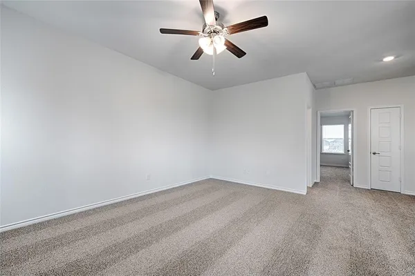 an empty room with chandelier fan