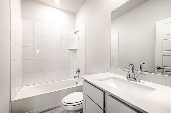 a bathroom with a granite countertop sink a toilet and shower